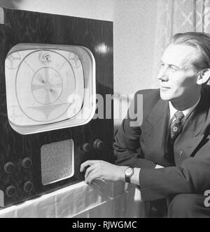 La televisión en la década de 1950. Un hombre con una temprana televisor ajuste de la imagen. Noviembre de 1953
