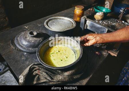 Preparación Harina de arroz y curry. Mujer preparando comida en casa tradicional cocina de Sri Lanka. Foto de stock