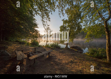 Sol levante temprano en la mañana en el lago en Suecia Foto de stock