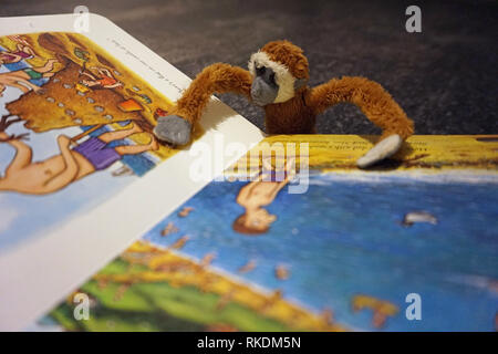 Soft Toy monkey leyendo un libro para niños Foto de stock