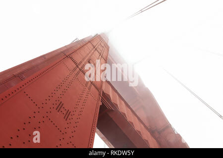 Bajo el ángulo de la cámara disparo en la estructura de la Torre del Puente Golden Gate en la niebla, San Francisco, California, EE.UU. Foto de stock