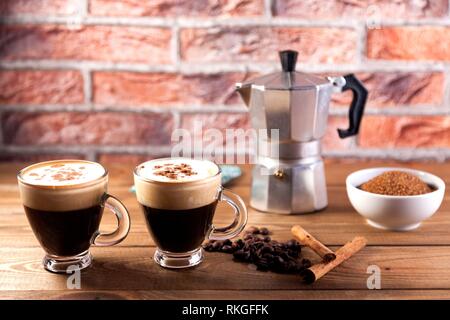 cafetera italiana y dos tazas de café con granos de café tostados en un  recipiente de madera 10842960 Foto de stock en Vecteezy