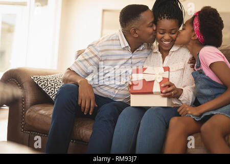 Feliz Afroamericanos padre e hija, madre besar en las mejillas