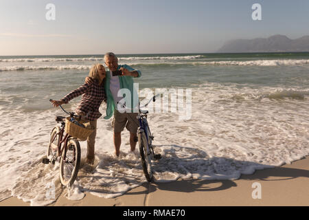 Las parejas ancianas teniendo selfie con teléfono móvil en la playa