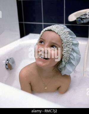 Niña con gorro de ducha en la bañera Fotografía de stock - Alamy
