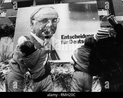 Los niños lanzar bolas de nieve a un póster de la CDU en el Bundestag 1987 campaña electoral. Foto de stock