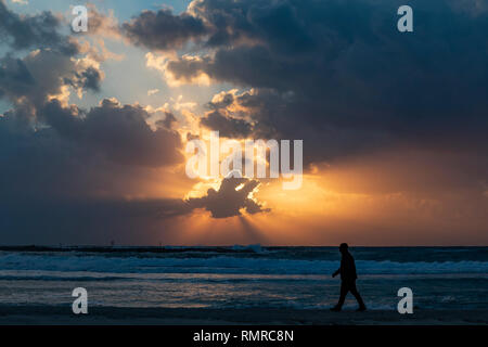 Una silueta de un hombre despierto en la playa de Sunset, fotografiado en Tel Aviv, Israel Foto de stock