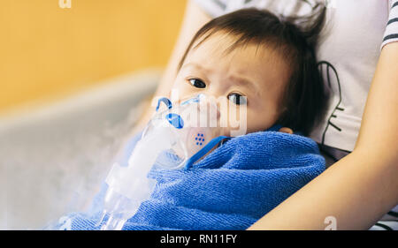 Tratamiento médico un niño que se enferma por una infección torácica después de un resfriado o la gripe que tiene dificultad para respirar y tos prolongada.un síntoma de asma. Foto de stock