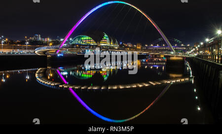 De Gateshead, Inglaterra, Reino Unido - Febrero 3, 2019: el puente del milenio de Gateshead se refleja en las aguas del río Tyne en la noche junto a la puerta de Salvia
