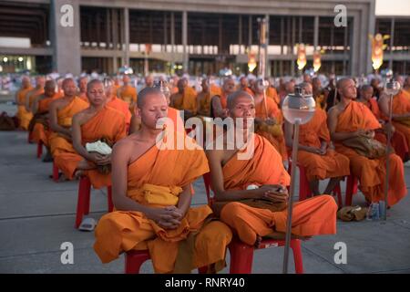 Visto monjes meditando durante la ceremonia anual de Makha Bucha en el norte de Bangkok. Los devotos budistas celebran el festival anual de Makha Bucha, uno de los días más importantes para los budistas de todo el mundo. Más de un millar de monjes y cientos de miles de devotos se reúnen en el templo Dhammakaya en Bangkok para asistir a la ceremonia de iluminación. Foto de stock