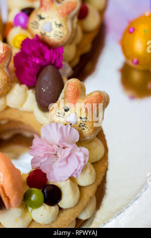 Detalles de una Torta de Pascua - pastel de vainilla decorado con macarrones y flores. Foto de stock