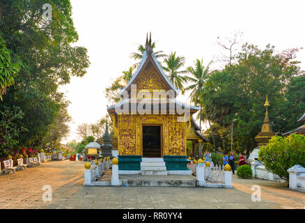 LUANG PRABANG - LAOS - 11 de febrero de 2019 algunos turistas son caminar y tomar fotos en el hermoso Wat Xieng Thong (Templo) de Oro de la ciudad al atardecer en