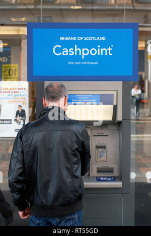 Hombre en ATM Bank of Scotland en Argyle Street, 'S t. Enoch', Glasgow, Escocia, Reino Unido Foto de stock