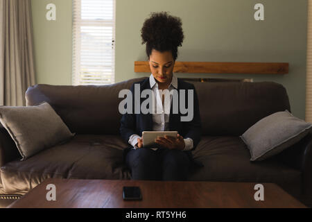 Agente inmobiliario femenino mediante tableta digital en el salón