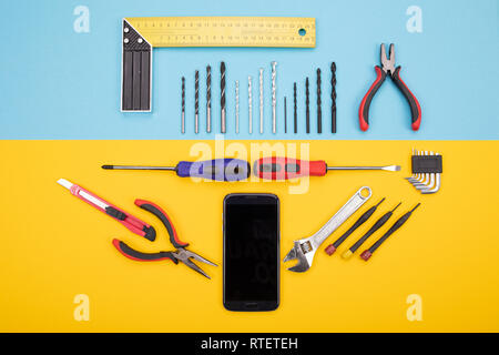 Conjunto de chapa herramientas con el smartphone en el fondo de colores Foto de stock
