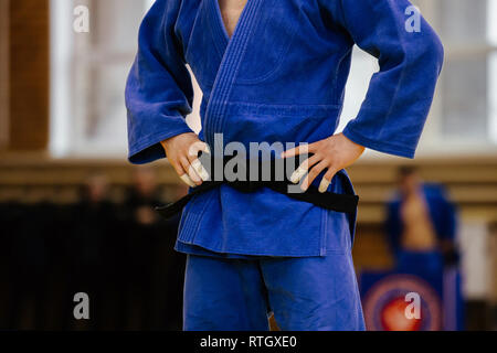 Atleta de judo en azul kimono y cinturón negro Foto de stock