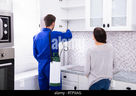 Aniquilar Hostil Registro La mujer se muestra en el control de plagas fumigaciones trabajador  insecticida sobre el estante de cocina doméstica Fotografía de stock - Alamy