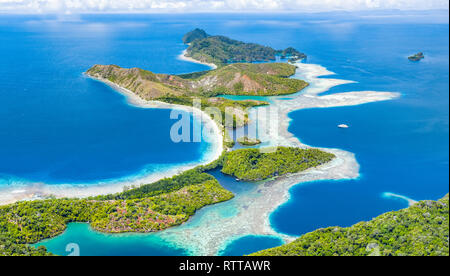 Vista aérea de islas de piedra caliza, rodeada por arrecifes de coral, las Islas Raja Ampat, Papua Occidental, Indonesia, Océano Pacífico Foto de stock