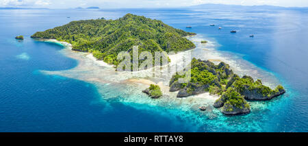 Vista aérea de islas de piedra caliza, rodeada por arrecifes de coral, las Islas Raja Ampat, Papua Occidental, Indonesia, Océano Pacífico Foto de stock