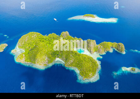 Vista aérea de un remoto conjunto de islas de piedra caliza, rodeada de hermosos arrecifes de coral, las Islas Raja Ampat, Papua Occidental, Indonesia, Océano Pacífico Foto de stock