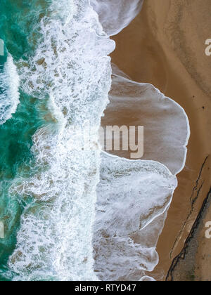 La playa de arena de la antena, vista superior de una hermosa playa de arena toma aérea con la rodadura olas azules en la orilla