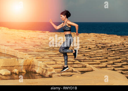 Mujer runner, corriendo a través de la caliza salinas en Malta.