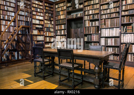 Estanterías con libros antiguos en la pequeña biblioteca del museo Plantin-Moretus / Plantin-Moretusmuseum acerca de impresoras del siglo XVI, Amberes, Bélgica