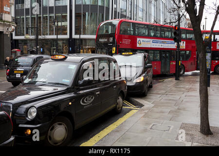 Con los motores en marcha, tradicional black cabs cola para tarifas, por consiguiente bloqueando el tráfico del bus fuera el Selfridge's department store en Oxford Street, el 4 de marzo de 2019, en Londres, Inglaterra.