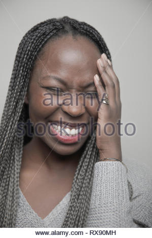 Retrato despreocupado hermosa joven afroamericana con largas trenzas negras riendo