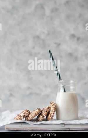Pila de horneado tahini galletas con trocitos de chocolate con una botella de leche