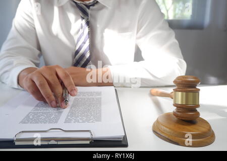 Asesor jurídico presenta un contrato con martillo y legales; la justicia y el abogado concepto