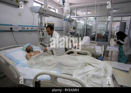 Sanaa, Yemen. 12 Mar, 2019. Un médico yemenita comprueba un hombre que resultó herido durante un ataque aéreo informó en un hospital. Según la ONU, un periodo de 48 horas las huelgas mató a 22 personas, incluyendo una docena de niños, a principios de esta semana. Crédito: Hani Al-Ansi/dpa/Alamy Live News Foto de stock