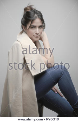 Retrato seguros hermosa latina joven mujer vistiendo abrigo beige