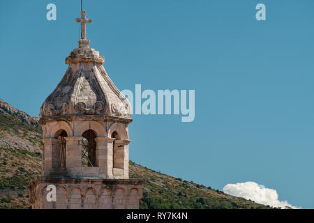 La parte superior de un antiguo campanario y adornados con un cielo azul en un día de verano, Dubrovnik, Croacia