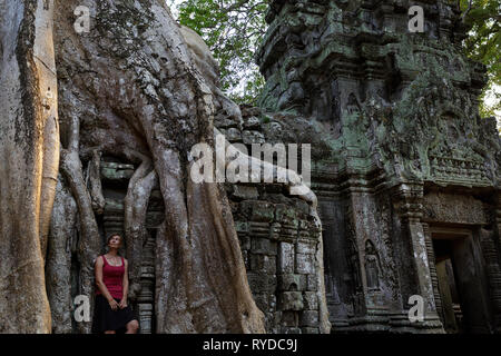 Mujer Ta Prohm visitando el antiguo templo en la zona arqueológica de Angkor en Camboya al atardecer