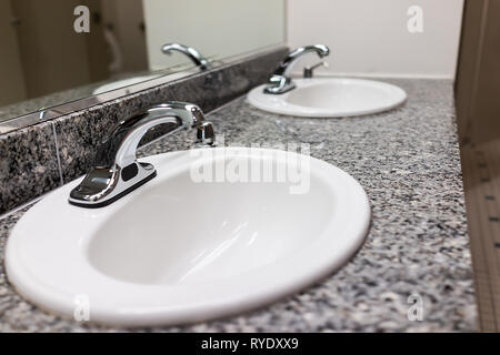 Fila de lavabos modernos en público WC baño con jabón y limpie el interior con fondo blanco minimalista closeup grifo de metal y granito Foto de stock