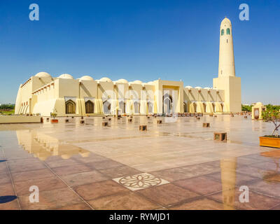 Estado Gran Mezquita, con un minarete reflexionando sobre pavimento de mármol en el exterior. Mezquita en el Centro de Doha, Qatar, en Oriente Medio, la Península Arábiga. Mañana