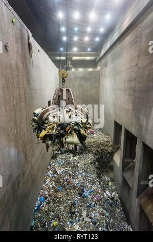 Brazo de agarre encima del montón de basura, una grúa transporta los residuos en una planta de incineración de residuos, TREA Breisgau, Eschbach Foto de stock