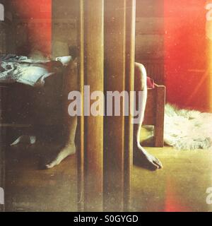 Despertarse por la mañana. La resaca. Imagen de un hombre sentado en una cama. Reflejo en el espejo de un armario de doble puerta.