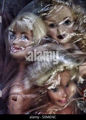 Tres muñecas Barbie en una bolsa de plástico Foto de stock