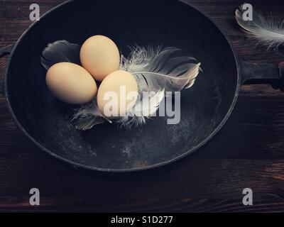 Tres huevos de gallina negra en un sartén de hierro fundido Foto de stock
