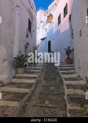 Romántica típica calle estrecha en la famosa ciudad blanca de Ostuni, Puglia, Italia Foto de stock