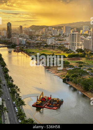 Plataforma de dragado en el Canal Ala Wai en Honolulu, Hawai al atardecer Foto de stock