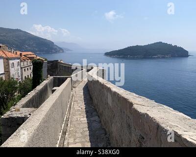 Murallas de la ciudad vieja de Dubrovnik con el océano en el fondo Foto de stock