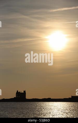 Puesta de sol sobre el castillo y el océano en Quiberon , Bretaña, Francia Foto de stock