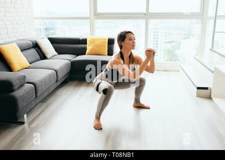 Mujer adulta formación haciendo piernas sentadilla In y Out Foto de stock