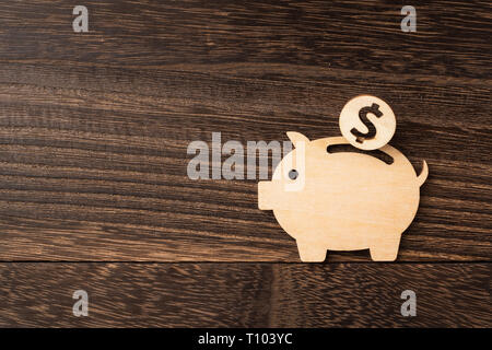 Concepto de diseño y financieros - madera hucha de cerdo trozo de madera oscura de fondo. es ahorro, inversión, concepto Foto de stock