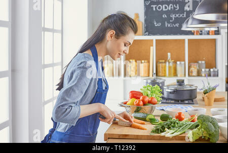 Una joven mujer prepara la comida en la cocina. Alimentos saludables - vege
