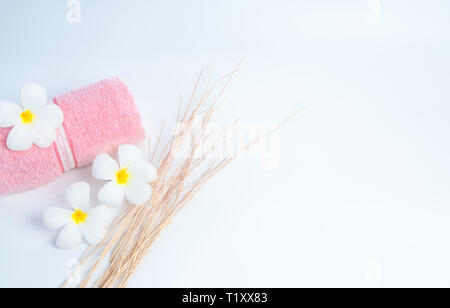Spa Rosa toalla enrollada y Frangipani flores con rama sobre fondo blanco. Spa y centro de bienestar del hotel o resort. Antecedentes para el baño y Foto de stock