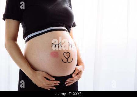  La barriga de la mujer embarazada con gracioso dibujo sobre fondo blanco  Fotografía de stock - Alamy